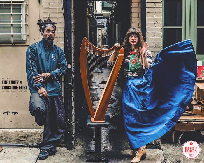 Image of hip-hop artist Kuf Knotz and harpist Christine Elise standing on either side of her harp.