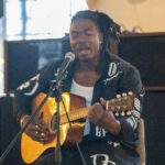 R&b / rap artist Gully Mills playing an acoustic guitar